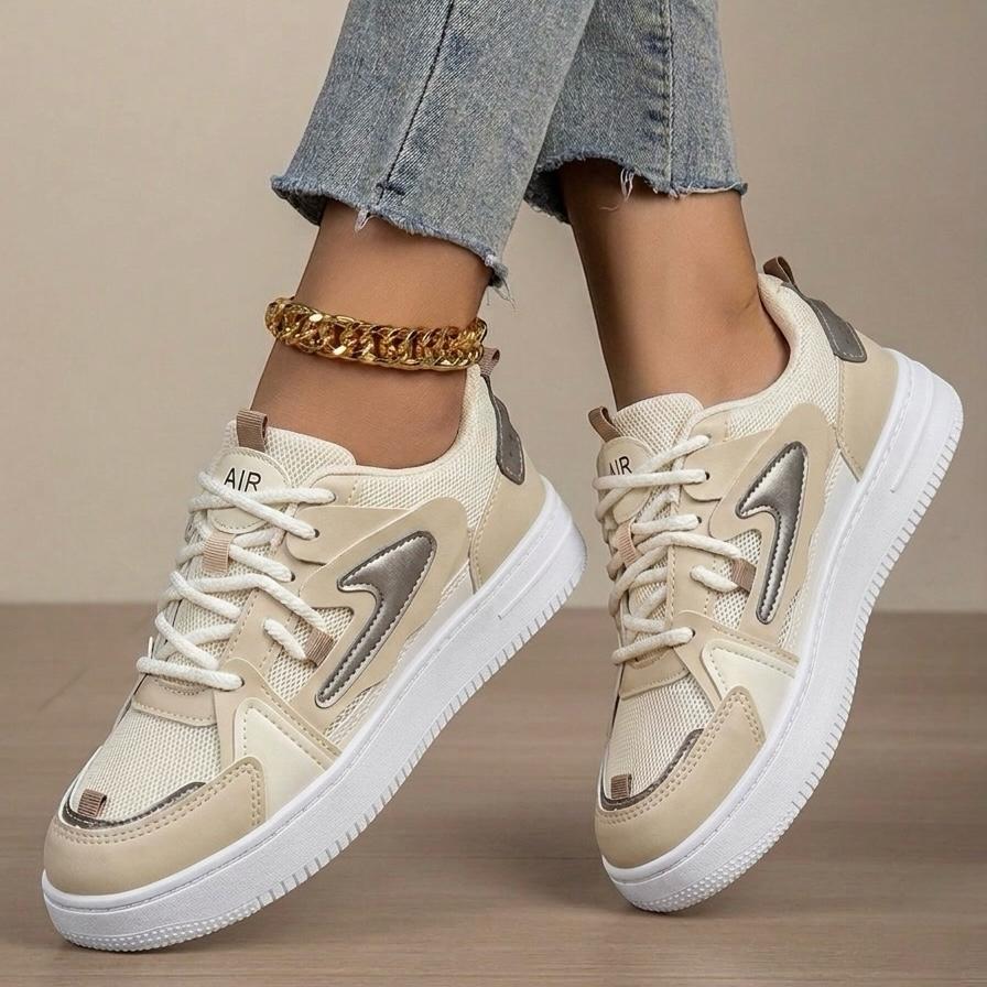 Beige sneakers with white soles worn by a person on a neutral background