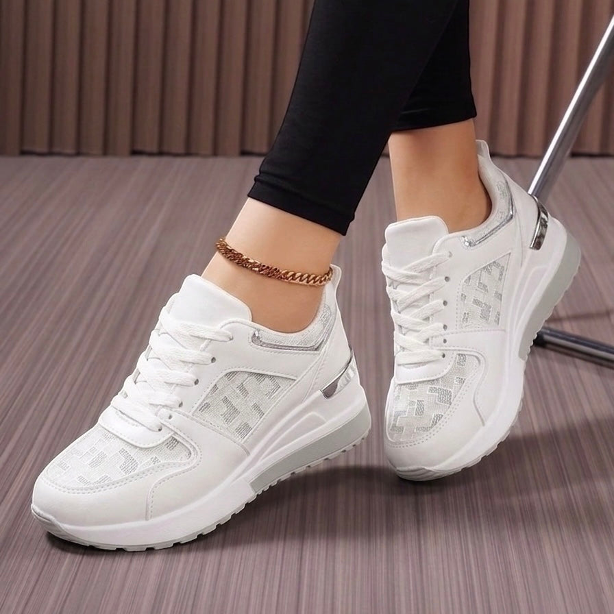 White sneakers worn on a neutral background